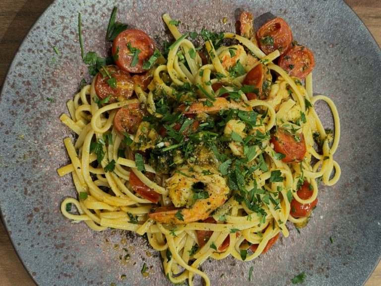 A plated pasta dish with prawns, overhead view