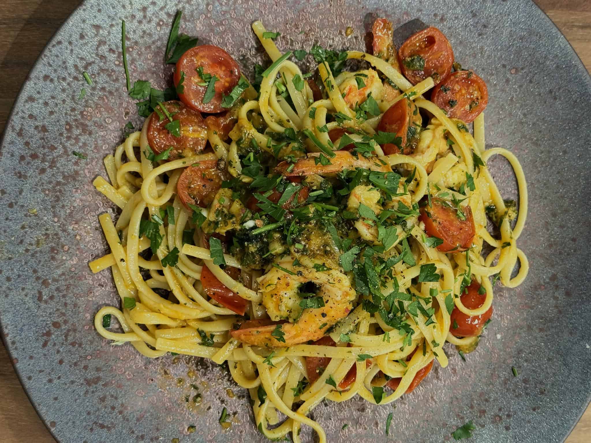 A plated pasta dish with prawns, overhead view